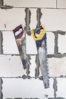 Köpük bloklardan duvarda asılı iki testere