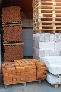 Tamir malzemeleri (tuğlalar ve köpük blokları) inşaat piyasasında paletlerin üzerine istiflenmiştir