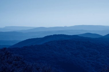 Sis içindeki alçak dağlar. Dokunulmamış sisli doğa 2020 yılının klasik mavi rengine bürünmüş adamdan uzakta.