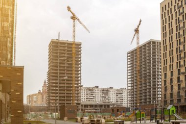 güzel modern çocuk parkı ve arka planda vinçleri olan inşaat halindeki yerleşim yeri.