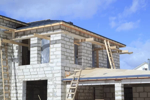带灰色折叠式屋顶防水层的脚手架和在建房屋 — 图库照片