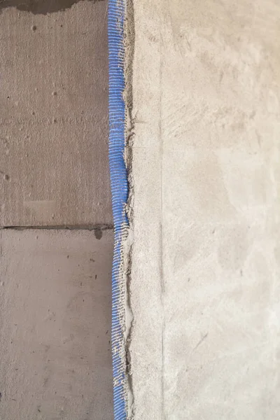 Wand Mit Aufgetragenem Putz Und Blauem Verstärkungsgitter Das Darunter Herausragt — Stockfoto