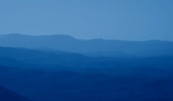 low mountains in mist colored in trendy Classic Blue color of the year 2020