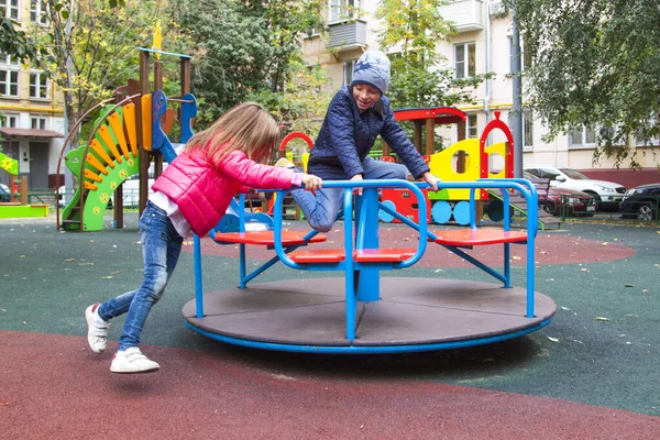 Mädchen Pinkfarbener Jacke Rollt Jungen Auf Karussell Auf Spielplatz Freien — Stockfoto