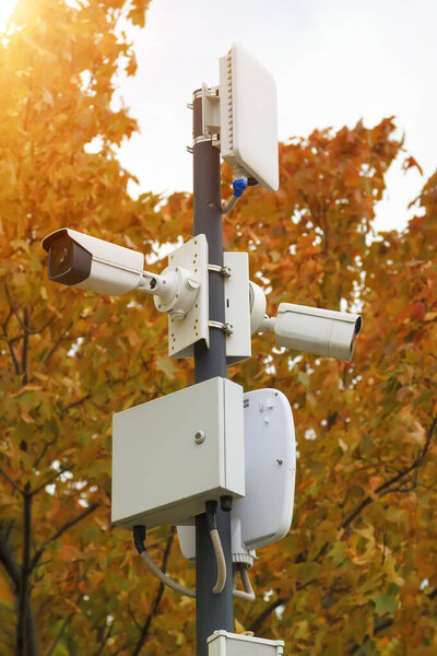 outdoor surveillance cameras and wireless access points in autumn city park