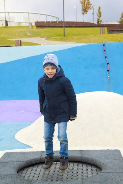 Menino Roupas Quentes Pulando Trampolim Parque Infantil Moderno Livre — Fotografia de Stock