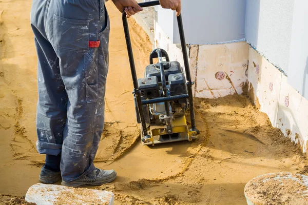 Werknemer Comprimeert Zand Blinde Gebied Rond Gebouw Met Speciale Werktuig — Stockfoto