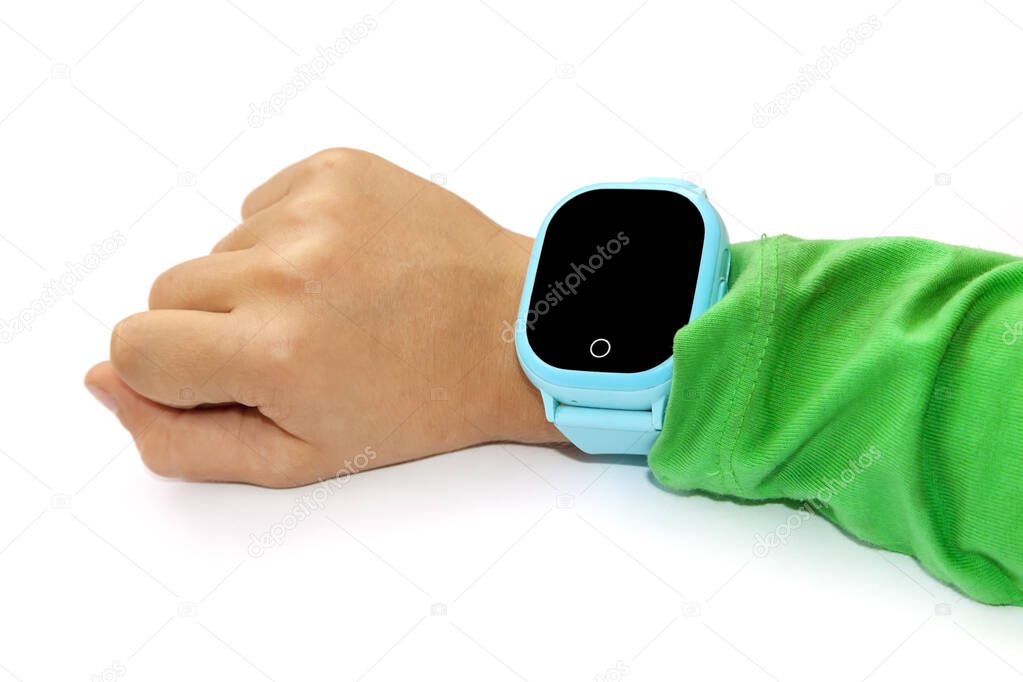 Blue smart digital watch on boy hand with green sleeve. Modern children technologies. GPS tracker for kids, child tracking and parental control concept.
