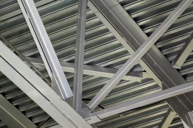 Metal kirişlerin birbirine yakın görüntüsü. Çatıyı tutan kanallardan yapılmış güçlü demir yapı.