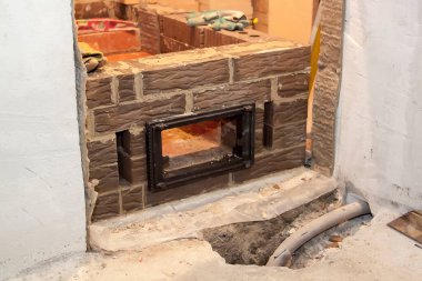 Kır evindeki köpük bloklardan inşa edilen ateşe dayanıklı malzemeden inşa edilen sauna sobası.
