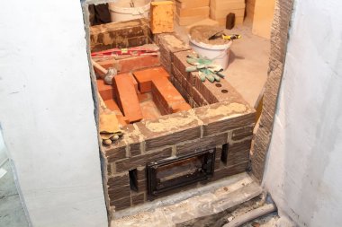 Kır evindeki köpük bloklardan inşa edilen ateşe dayanıklı malzemeden inşa edilen sauna sobası.