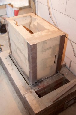 Kır evindeki köpük bloklardan inşa edilen ateşe dayanıklı malzemeden inşa edilen sauna sobası.