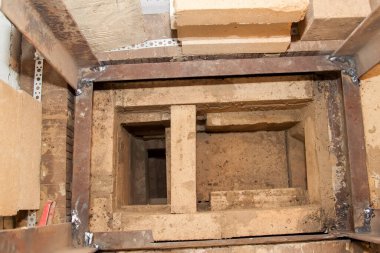 Köy evindeki köpük bloklardan geliştirilmemiş iç kısımlarda ateşe dayanıklı malzemeden inşa edilen sauna ocağının yakın görüntüsü.