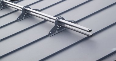 Metal kar koruyucuyu vidalarla gri çatıya bağlama görüntüsünü kapat