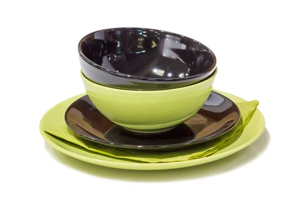 黑色和绿色的杯子被堆放在一个茶托上 茶托上的绿色餐巾与白色隔离在一起 — 图库照片