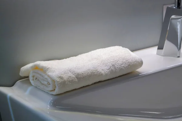 明るいバスルームの洗面台には白いタオルがきれいに折り畳まれ — ストック写真