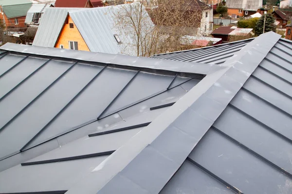Close-up view of an independent black metal folding roof and ventilation grilles with trees and sky behind — Stock Image Close View Independent Black Metal Folding Roof Ventilation Grilles Trees Stock Image