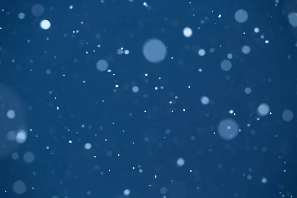 Падение снега на голубом фоне — стоковое фото