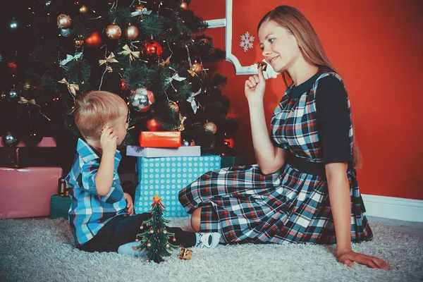 Hermoso retrato de feliz madre e hijo en el fondo del árbol de Navidad —  Fotos de Stock