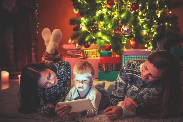 Madre e hijo sentados cerca del árbol de Navidad — Foto de Stock