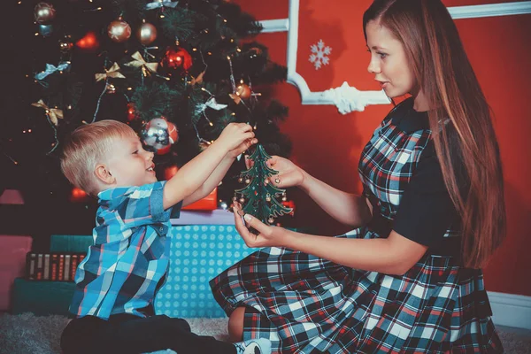 Matka a syn sedí u vánočního stromu — Stock fotografie