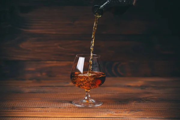 Pouring brandy from bottle — Stock Photo, Image