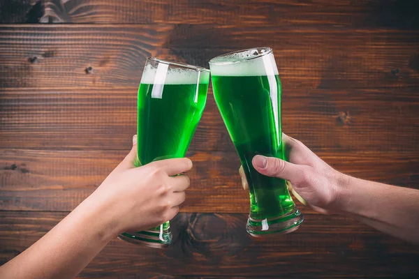 Muggar i händerna med grön öl — Stockfoto