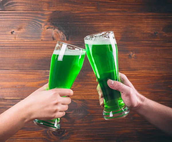 Canecas nas mãos com cerveja verde — Fotografia de Stock