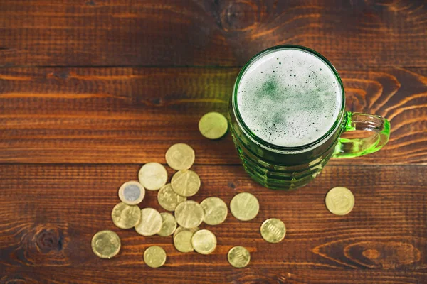 Glas mit grünem Bier und Goldmünzen — Stockfoto