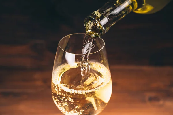 Pouring white wine from a bottle — Stock Photo, Image