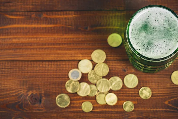 Glas mit grünem Bier und Goldmünzen — Stockfoto