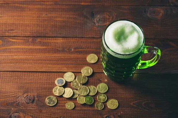 杯绿色的啤酒和金币 — 图库照片