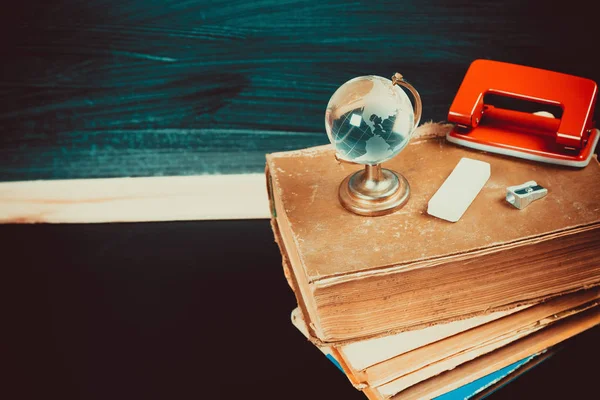 Vieux tableau noir avec fournitures scolaires — Photo