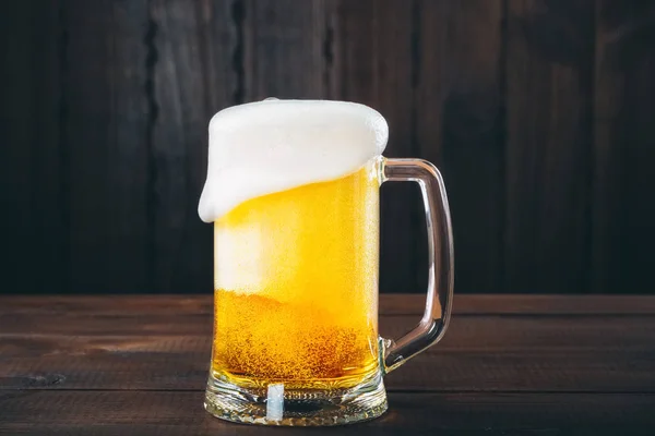 Mugg öl på trä bakgrund — Stockfoto
