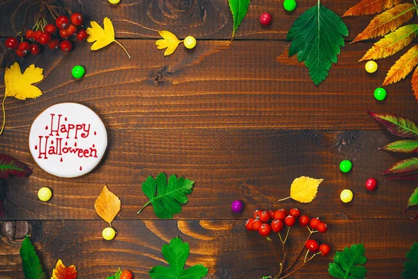 Gingerbread ile Cadılar Bayramı için güzel festival arka plan, sonbahar yaprakları, çilek ve şeker ahşap bir masa üzerinde. Boş alan