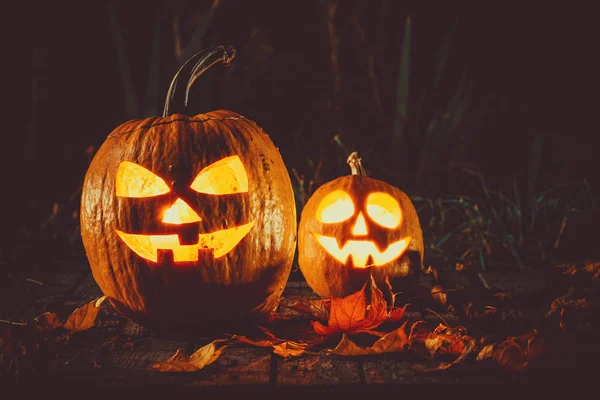 Halloween-Kürbisse mit leuchtenden Gesichtern — Stockfoto