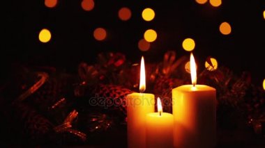 Noel ışıkları ile koyu arka plan üzerinde yanan mumlar