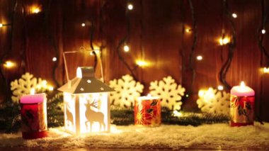 Fener geyik ve Noel ışıkları ile koyu arka plan üzerinde mum yakma