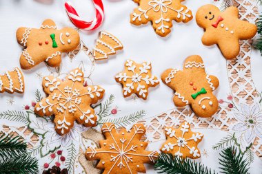 Noel gingerbread çerezleri Noel ağacı ve yılbaşı dekor beyaz masa örtüsü ile tabloda dalları ile ev yapımı. Neşeli Noel Kartpostalı