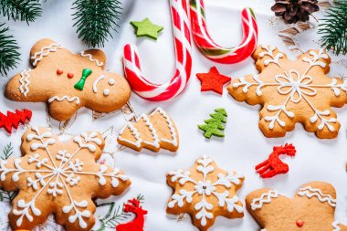 Noel gingerbread çerezleri Noel ağacı ve yılbaşı dekor beyaz masa örtüsü ile tabloda dalları ile ev yapımı. Neşeli Noel Kartpostalı