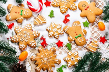 Noel gingerbread çerezleri Noel ağacı ve yılbaşı dekor beyaz masa örtüsü ile tabloda dalları ile ev yapımı. Neşeli Noel Kartpostalı