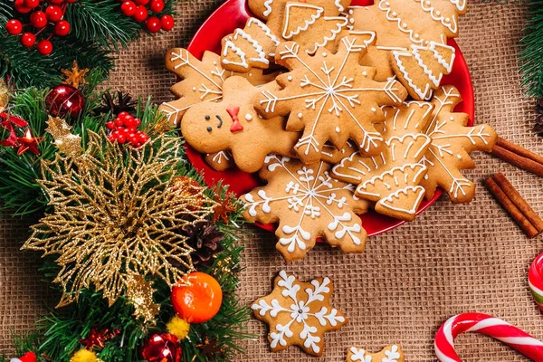 圣诞节姜饼饼干自制的红板与树枝的圣诞树和新年装饰在餐桌上的粗麻布桌布 圣诞快乐明信片 — 图库照片