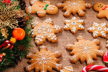 Noel gingerbread çerezleri Noel ağacı ve yılbaşı dekor çuval bezi masa örtüsü ile tabloda dalları ile ev yapımı. Neşeli Noel Kartpostalı.