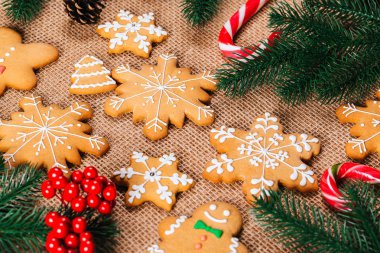 Noel gingerbread çerezleri Noel ağacı ve yılbaşı dekor çuval bezi masa örtüsü ile tabloda dalları ile ev yapımı. Neşeli Noel Kartpostalı.