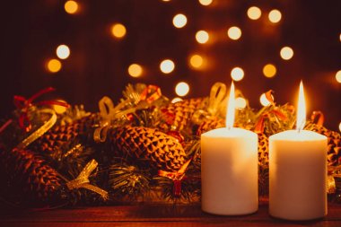 Geceleri parlak çelenk bokeh arka plan üzerinde ahşap masa üstünde mumlar yanan Noel