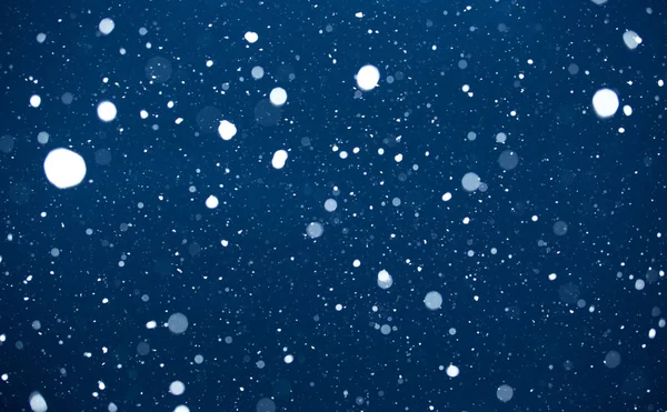 Padající sníh na modrém pozadí. — Stock fotografie
