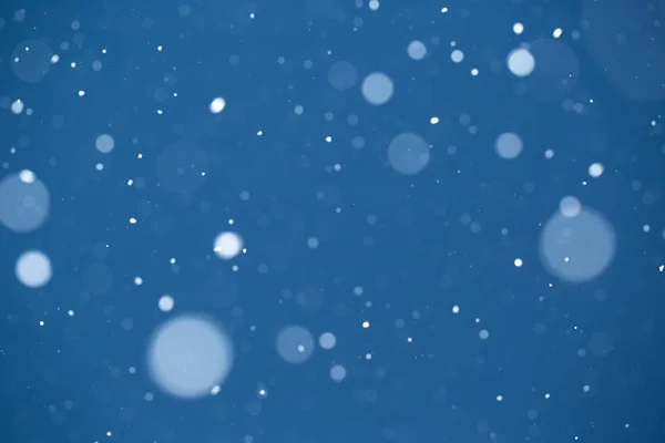 Padající sníh na modrém pozadí. — Stock fotografie