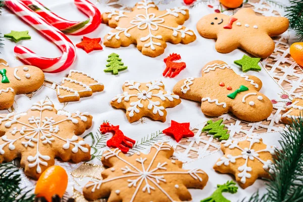 Noel gingerbread çerezleri Noel ağacı ve yılbaşı dekor beyaz masa örtüsü ile tabloda dalları ile ev yapımı. Neşeli Noel Kartpostalı
