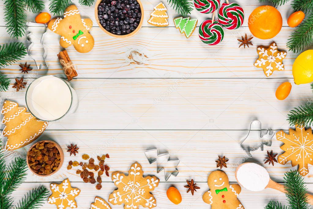 Cooking Christmas gingerbread cookies with the ingredients, dough, candy and winter spices decorating for new year celebration on white wooden table. Xmas food frame background