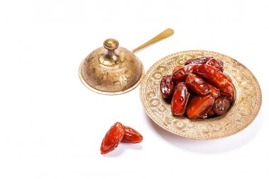 Beyaz bir arka plan üzerinde geleneksel bir tepsi üzerinde kurutulmuş tarihleri. Ramazan Kareem